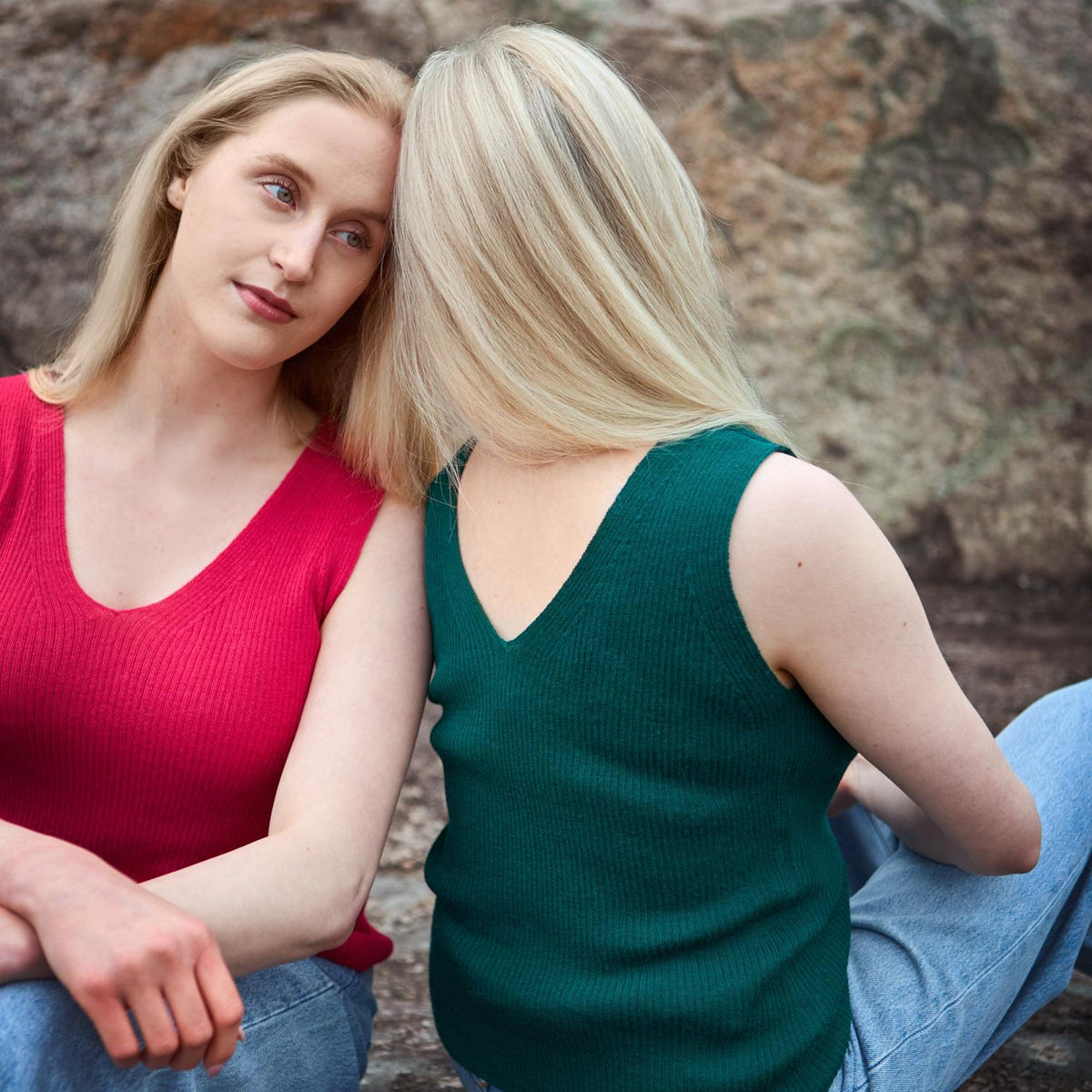 Two women wearing Flow alpaca tops in red and green