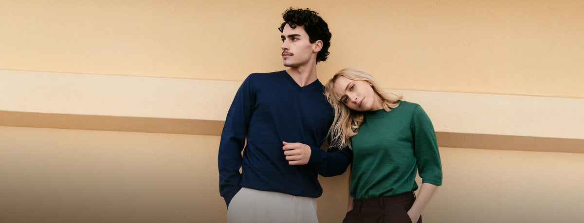 Couple wearing alpaca knitwear in navy and green